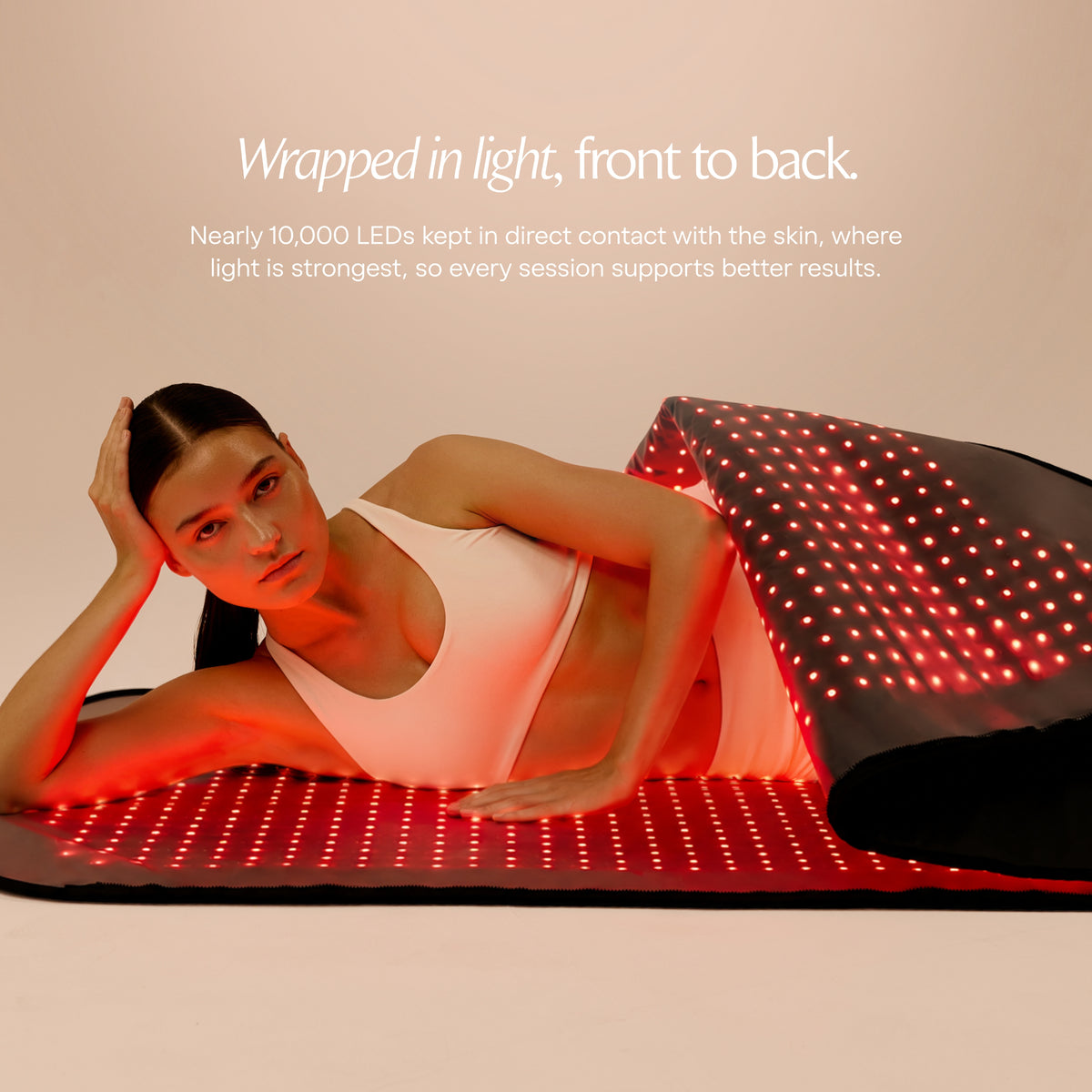 Woman lying between the illuminated upper and lower panels of the Restora+ light therapy pod