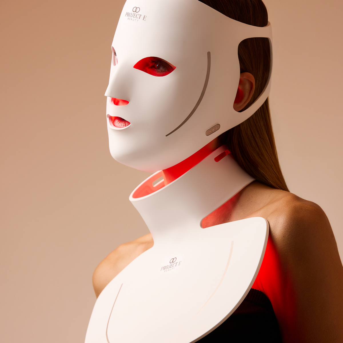 Woman wearing the illuminated LumaLux Face+ V2 face and neck mask, shown from the side