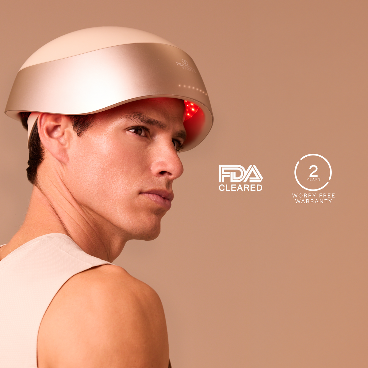 Man wearing the LumaLase laser hair growth helmet beside FDA-cleared and 2-year warranty badges